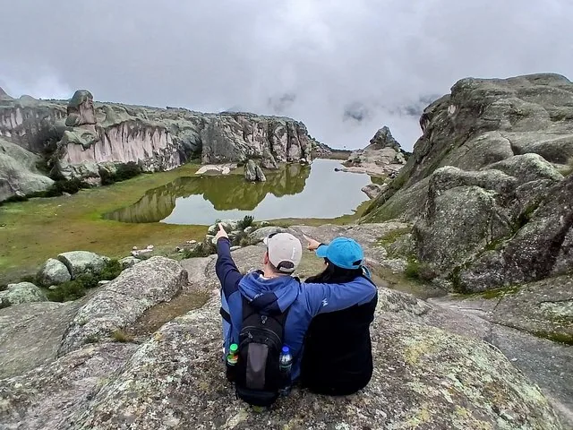 Two people pointing at a lake and rock formations at Marcahuasi