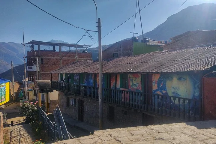 Village street in Marcahuasi showing a building decorated with vibrant street art.
