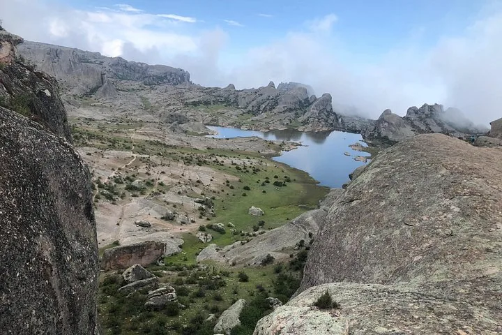 Ein großer See, umgeben von felsigen Hügeln und grünen Tälern in Marcahuasi